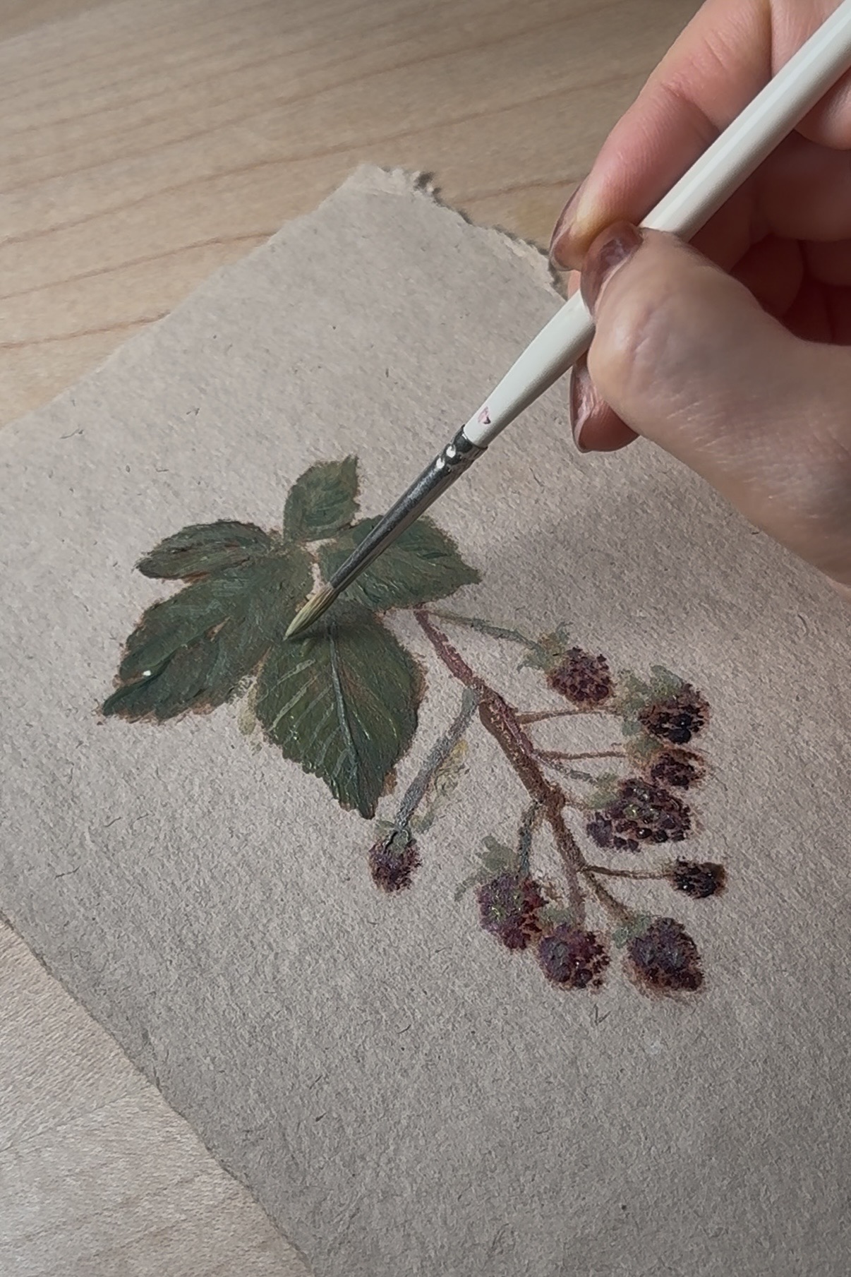 nature artist Jas Olivette painting autumn berries on handmade paper